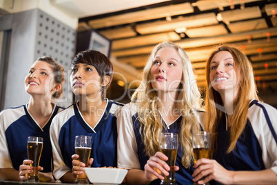 Female fan watching football at bar counter