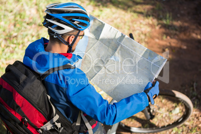 Male mountain biker looking at map