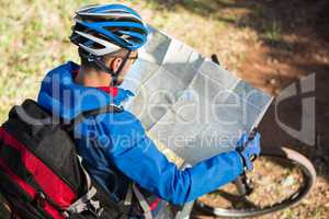Male mountain biker looking at map