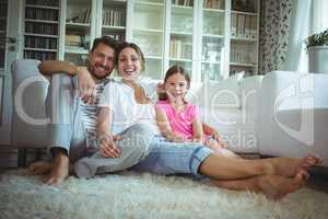 Happy family sitting on the rug in living room