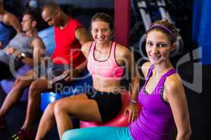 Smiling friends sitting on exercise ball