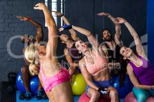 Athletes smiling while exercising in fitness studio