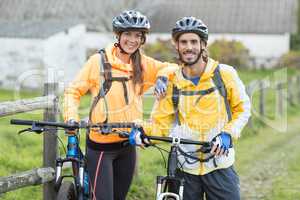 Biker couple with mountain bike in countryside