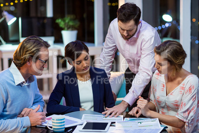 Businesspeople discussing on documents in office Businesspeople discussing on documents in office