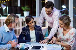 Businesspeople discussing on documents in office