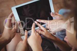 Family pointing their fingers at digital tablet