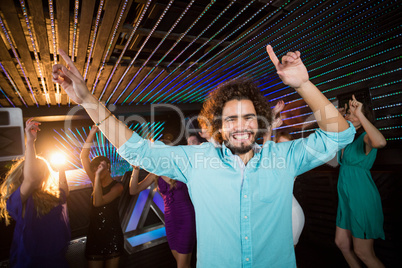 Group of smiling friends dancing on dance floor