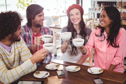 Group of happy friends holding cup of coffee