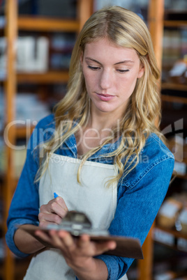 Female staff writing on clipboard