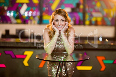 Portrait of young woman leaning on table