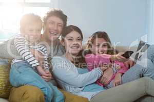 Family watching television while sitting on sofa