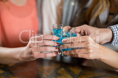 Group of friends having tequila shots in bar