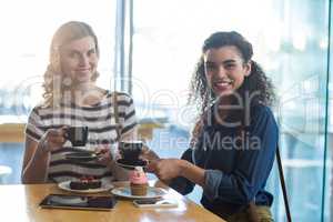 Smiling woman having coffee in cafÃ?Â©