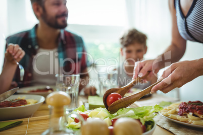 Woman serving meal to her family