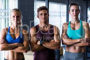 Confident friends with arms crossed in gym