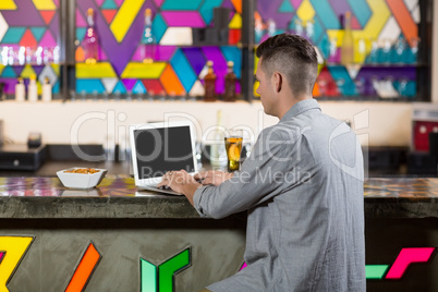 Man using laptop in bar