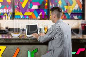 Man using laptop in bar