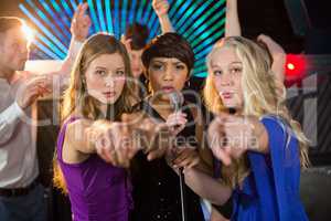 Female friends singing song together in bar