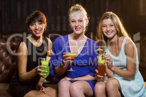 Friends holding glass of cocktail in bar