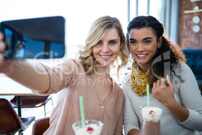 Female friends taking a selfie on mobile phone