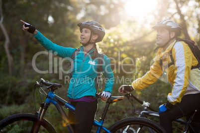 Biker couple with mountain bike pointing in distance