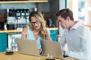 Man and woman using laptop during meeting