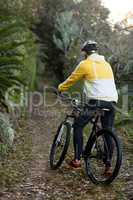 Male biker with mountain bike in forest