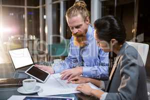 Businesswoman and colleague discussing over blueprint