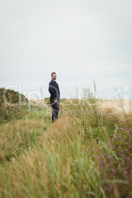 Thoughtful farmer standing in field