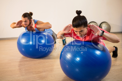 Men exercising on exercise ball