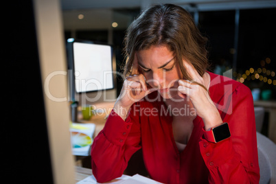 Stressed businesswoman sitting in front of computer