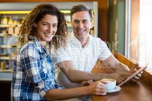 Portrait of happy couple using digital tablet in cafÃ?Â©