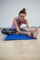 Portrait of smiling woman doing stretching exercise