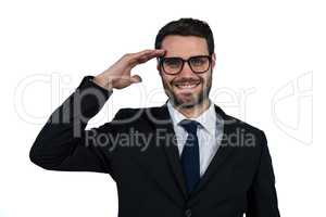 Businessman saluting against white background