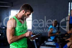Hipster man using tablet in gym