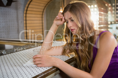 Depressed woman sitting at bar counter