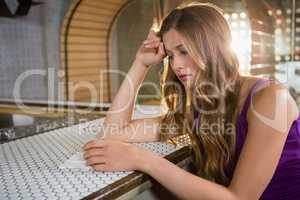 Depressed woman sitting at bar counter