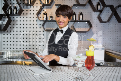 Waitress using digital tablet in bar counter