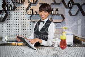 Waitress using digital tablet in bar counter