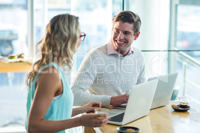 Man and woman using laptop during meeting