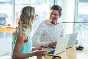 Man and woman using laptop during meeting