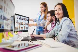 Businesswoman with coworkers at desk