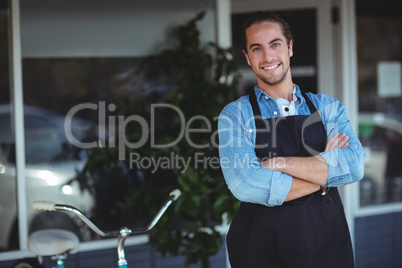 Waiter standing with arms crossed outside the cafe