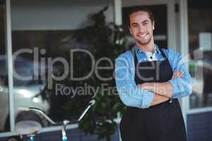 Waiter standing with arms crossed outside the cafe