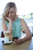 Woman using her mobile phone in the coffee shop