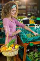 Smiling woman buying vegetables in organic section