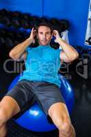 Portrait of male athlete using exercise ball