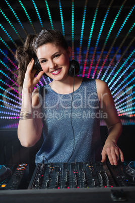 Pretty female DJ playing music