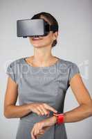 Woman touching smart watch and using virtual reality headset