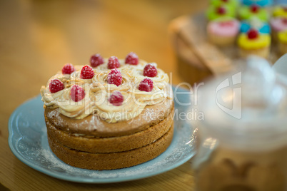 Sponge cake with whipped cream and cherry topping on plate